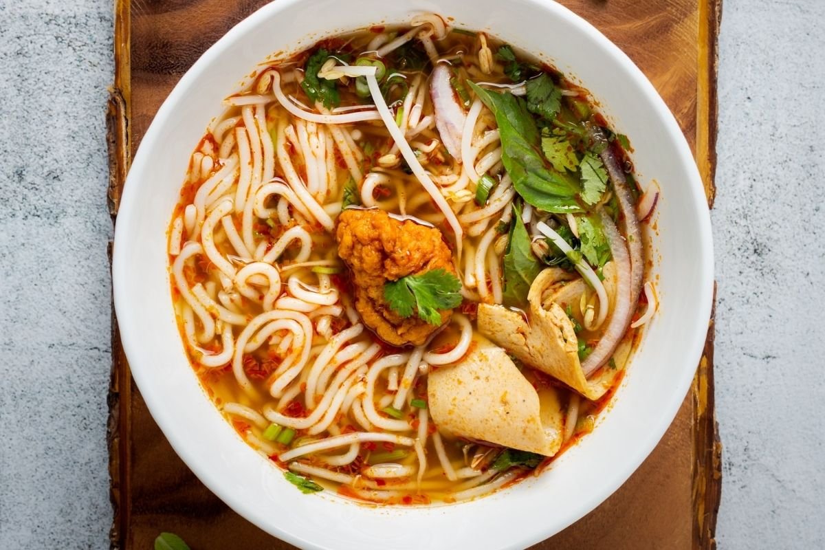 bowl of noodle soup on wooden plank